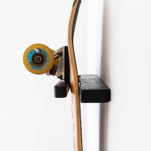 Suporte vertical de parede para skate em carvalho escurecido — suporte minimalista preto, fabricado na França.
