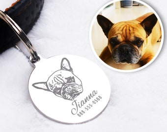 May include: A silver pet tag with a detailed engraving of a French Bulldog's face. The tag includes the name "Tianna" and a phone number. The tag is attached to a black and brown leather dog collar.