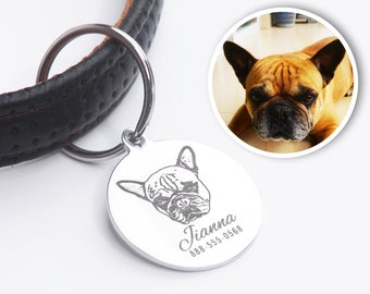 May include: A round, silver pet tag with a detailed engraving of a French Bulldog's face. The tag includes the name "Jianna" and a phone number. The tag is attached to a black leather dog collar with a silver ring.