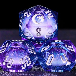 May include: Three polyhedral dice in shades of blue and purple, featuring silver numbering and a celestial design. These dice are designed for tabletop role-playing games and have a moon and star design.