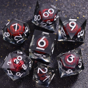 May include: A set of seven polyhedral dice made of clear resin, each containing a realistic red iris and black pupil. The dice feature white engraved numbers, including a d20, d12, d10, d8, d6, d4, and a percentile die, all arranged on a dark surface.