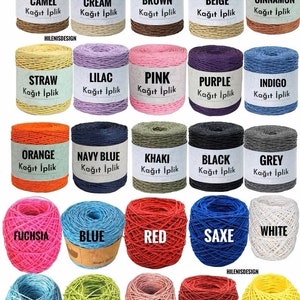 May include: A collection of twenty-five spools and balls of paper yarn in various colors including camel, cream, brown, beige, cinnamon, straw, lilac, pink, purple, indigo, orange, navy blue, khaki, black, grey, fuchsia, blue, red, saxe, white, baby blue, green, rose gold, maroon, and yellow.