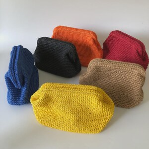 Puede incluir: Una colecci&oacute;n de seis bolsos peque&ntilde;os y rectangulares hechos de material tejido en colores vibrantes que incluyen azul, negro, naranja, rojo, beige y amarillo. Cada bolso presenta una abertura de marco estructurado y una superficie texturizada.