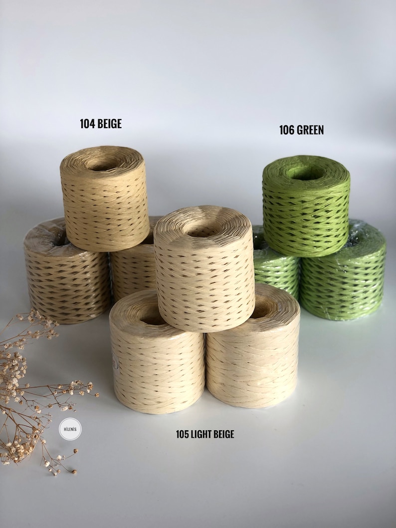 May include: Three spools of paper twine in beige and green. The spools are stacked on a white surface. The spools are labeled 104 Beige, 105 Light Beige, and 106 Green.