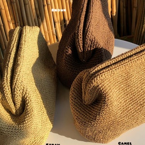 Puede incluir: Tres bolsos estructurados con textura tejida, cada uno en un color distinto: paja, marr&oacute;n y camel. Los bolsos tienen una apertura de marco con bisagras. Una peque&ntilde;a tarjeta blanca con el texto HILENIS se encuentra en la parte inferior.