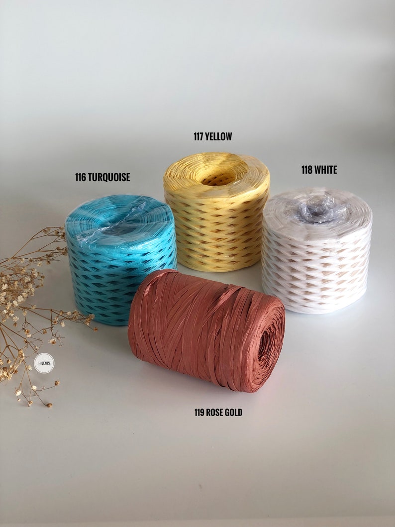 May include: Four spools of paper twine in different colors: turquoise, yellow, white, and rose gold. The spools are labeled with their corresponding colors and numbers.
