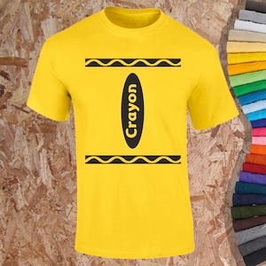 May include: Yellow t-shirt featuring a black crayon design. The design includes a black oval with the word "Crayon" in white, and two black wavy lines above and below the oval. The shirt is made of a soft material.