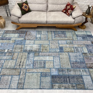 May include: A blue and gray patchwork rug with a geometric pattern. The rug is made of different pieces of fabric sewn together.