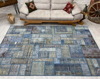 May include: A blue and gray patchwork rug with a geometric pattern. The rug is made of different pieces of fabric sewn together.