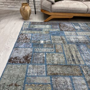 May include: A blue and brown patchwork rug with a distressed look. The rug is made of different pieces of fabric sewn together.