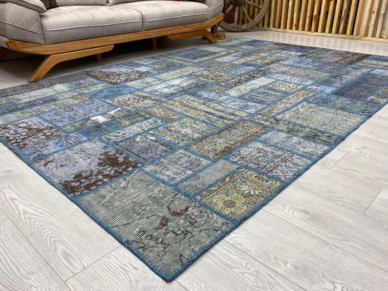 May include: A blue and brown patchwork rug with a variety of patterns and textures. The rug is made from recycled materials and is perfect for adding a touch of bohemian style to any room.