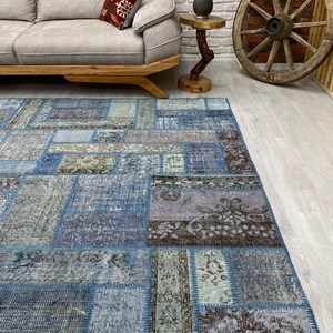 May include: A blue patchwork rug with a variety of patterns and textures. The rug is made from recycled materials and has a distressed look.