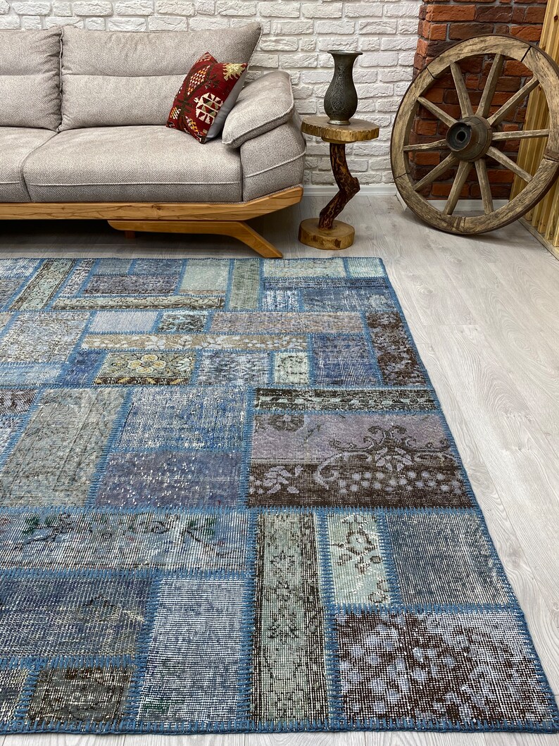 May include: A blue patchwork rug with a variety of patterns and textures. The rug is made from recycled materials and has a distressed look.