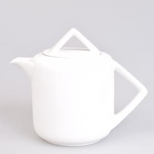 Op de afbeelding: Een matwitte keramische theepot met een cilindrisch lichaam, een korte gebogen tuit en een opvallend driehoekig handvat. Het deksel is voorzien van een bijpassende driehoekige knop, wat zorgt voor een samenhangende geometrische uitstraling.