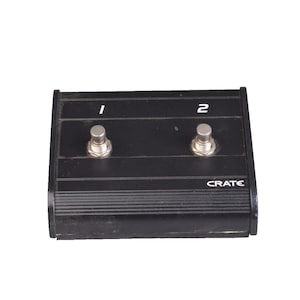 May include: Black Crate footswitch with two silver foot pedals labeled "1" and "2". The word "CRATE" is printed on the front of the device. The footswitch is designed for use with musical instruments.