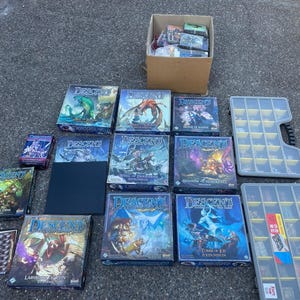 May include: A collection of Descent board game boxes, including base games and expansions like Well of Darkness, Shadow of Nerekhall, and Tomb of Ice. The set features a cardboard box filled with components, two plastic storage cases, and game manuals.