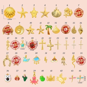 May include: A collection of gold-colored charms in various shapes, including seashells, starfish, crosses, and animals. Some charms are adorned with colorful enamel. Measurements are provided for some charms, such as 26mm x 23mm.