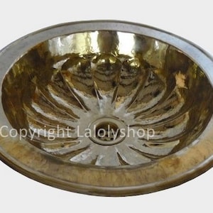 May include: A gold-toned ceramic sink with a fluted design and a round drain.