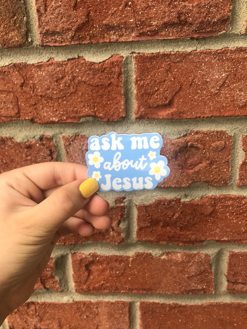 May include: A blue sticker with white daisies and the text "ask me about Jesus" in a white outline.