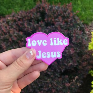 May include: Pink heart-shaped sticker with the text "love like Jesus" in white lettering.