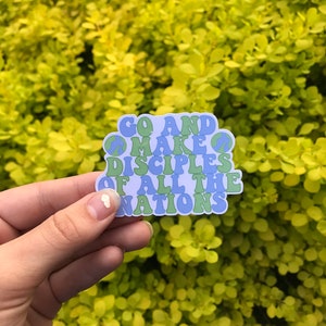 May include: A blue and green sticker with the text "Go and make disciples of all the nations" in a retro font. Peace signs are incorporated into the design.