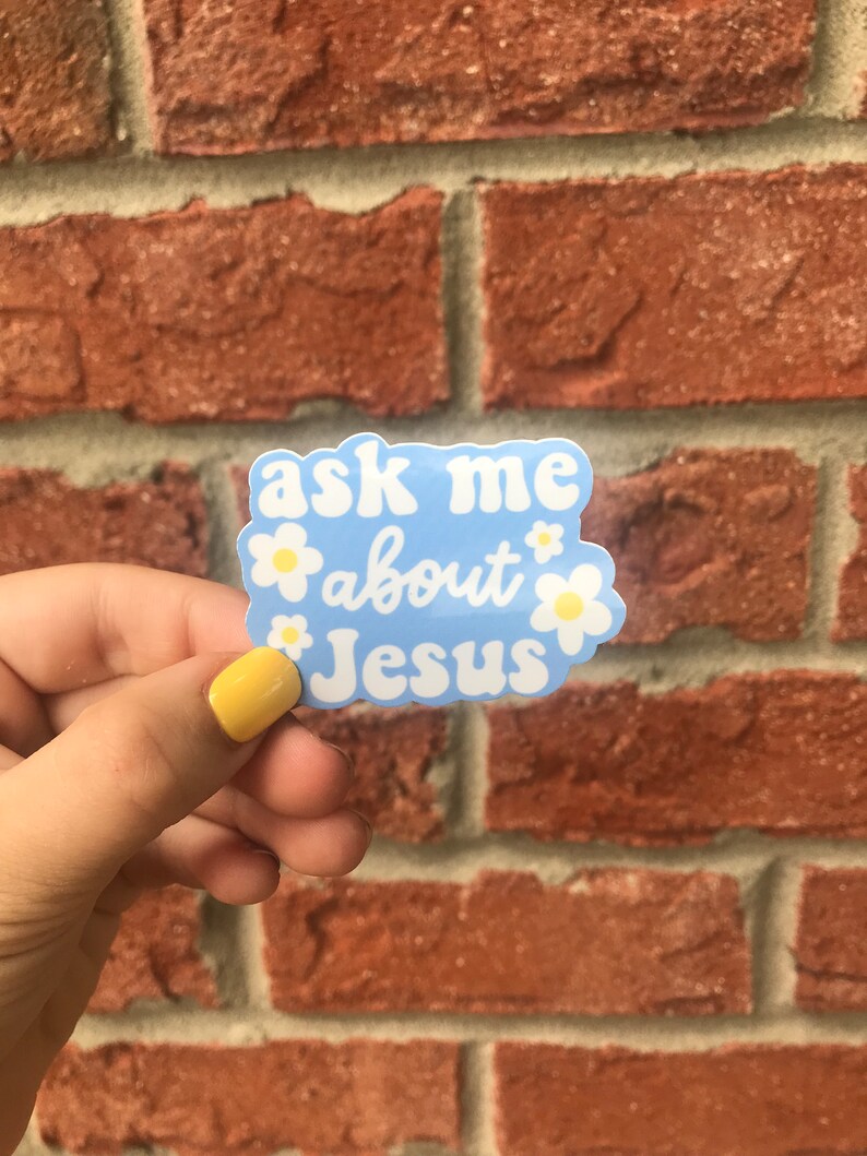 May include: A blue sticker with white daisies and the text "ask me about Jesus" in a white, cursive font.