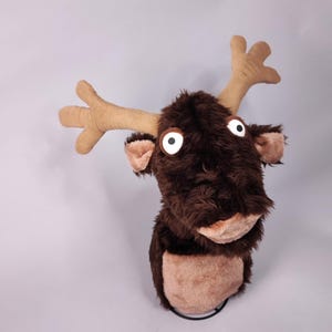 May include: A brown plush reindeer head with large white eyes and a brown nose. The reindeer has a brown and tan fur and large antlers.