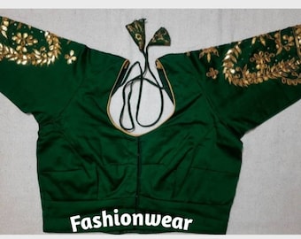May include: A dark green blouse with gold embroidery on the sleeves and neckline. The blouse has a scoop neckline and a tie closure at the back. The word "Fashionwear" is printed at the bottom of the image.