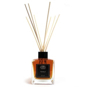 May include: A clear glass bottle with a black lid and brown liquid inside. The bottle is filled with diffuser sticks and has a label that reads "EUSPHYTICA Patchouli 200ml".