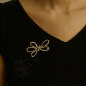 Broche vintage con lazo de diamantes de imitación, tono plateado, estilo cinta brillante, detalle nupcial glamuroso de mediados de siglo, falta una piedra.