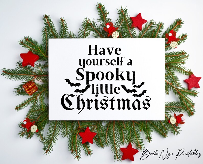 K&ouml;nnte beinhalten: Ein wei&szlig;es bedruckbares Schild mit schwarzem Text, der "Have yourself a Spooky little Christmas" lautet, mit Flederm&auml;usen um das Wort "little". Das Schild ist von gr&uuml;nen Kiefern&auml;sten und roten Sternenschmuck umgeben.