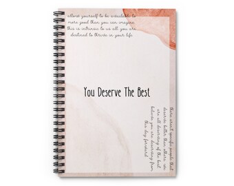 May include: A spiral-bound notebook with a cream-colored cover featuring the text "You Deserve The Best." The cover has watercolor-style orange and brown accents and inspirational text. The notebook is on a white background.
