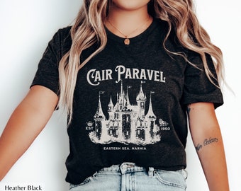 May include: A heather black t-shirt with a white graphic of Cair Paravel, a castle from the book "The Chronicles of Narnia". The graphic includes the text "Cair Paravel", "Est 1950", and "Eastern Sea, Narnia".