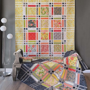 May include: A colorful quilt with a grid pattern, featuring squares of floral and geometric designs in shades of yellow, red, orange, and green. The word "FRINGE" is at the top. The quilt is displayed on a bed and wall.