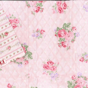 Può includere: Tessuto trapuntato rosa con un motivo floreale di rose rosse e rosa, foglie verdi e piccoli fiori viola. Il tessuto ha un motivo a rombi e uno sfondo bianco a pois. Un pezzo di tessuto più piccolo con un design floreale a righe è nell'angolo.