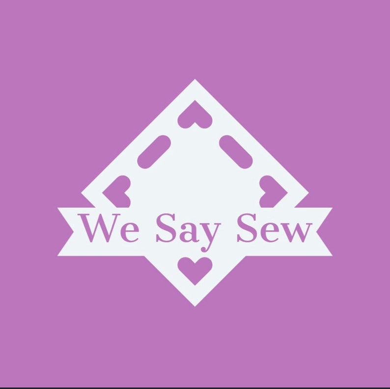 May include: A white logo on a purple background. The logo is a diamond shape with heart cutouts and the words "We Say Sew" in a banner across the bottom. The background is a solid, light purple color.
