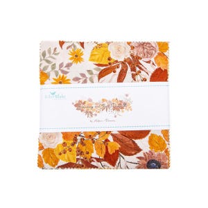 Könnte beinhalten: Ein Stapel Stoffquadrate mit einem Blumen- und Blättermuster in Orange-, Gelb- und Brauntönen. Der Stoff ist mit einem weißen Band umwickelt, auf dem "Spinning me the Prairie" von Nathan Paririe steht.