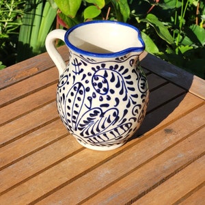 Hand-painted Spanish ceramic small jug featuring a traditional blue and white floral pattern. This authentic Mediterranean pottery has a glossy glazed finish and intricate artisan detailing.