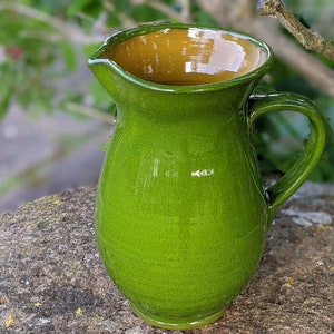 May include: A white ceramic mug with a black handle and the text "But First, Coffee" in a handwritten style. The mug is on a white surface. Suitable for hot drinks.