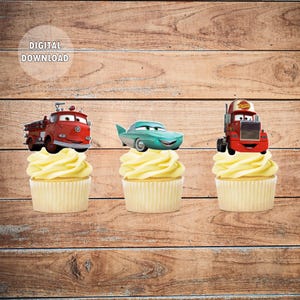 May include: Three cupcake toppers featuring characters from the Disney Pixar movie Cars. The toppers are a red fire truck, a teal sports car, and a red tow truck. The toppers are on top of cupcakes with white frosting.