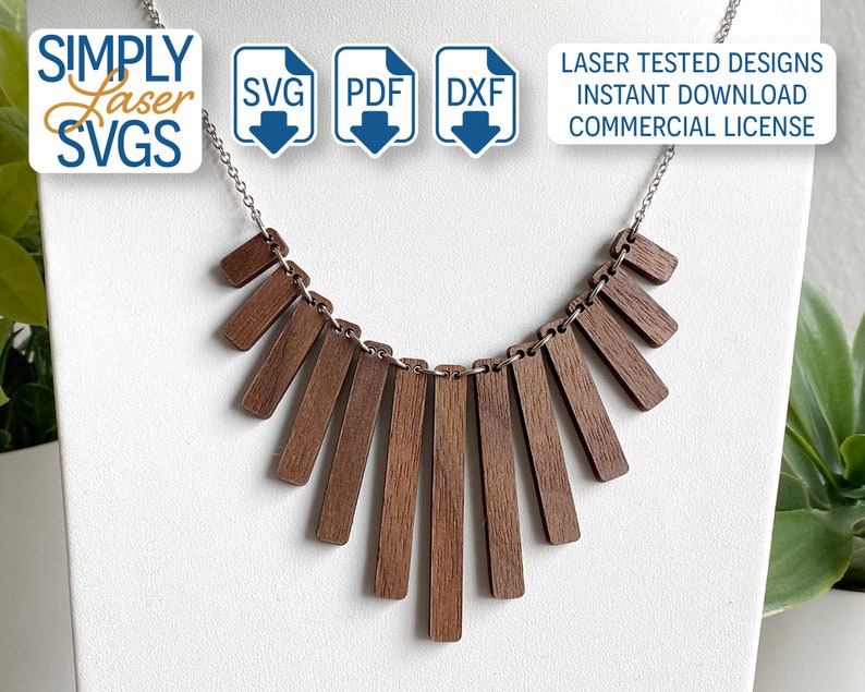 May include: A wooden necklace with a geometric design. The necklace is made of multiple rectangular pieces of wood that are arranged in a fan shape. The necklace is on a silver chain.