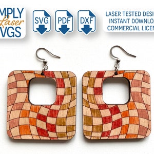 Peut inclure: Une paire de boucles d'oreilles carrées en bois avec un motif à carreaux dans des tons d'orange, de rouge et de brun. Les boucles d'oreilles ont une découpe carrée au centre et sont attachées à des crochets argentés.