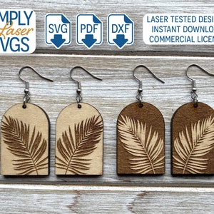May include: Four pairs of wooden earrings with a laser-cut design of a palm leaf. The earrings are a light brown color and have silver hooks.