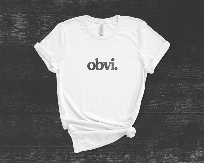 May include: White t-shirt with the word "obvi." printed in black on the front.