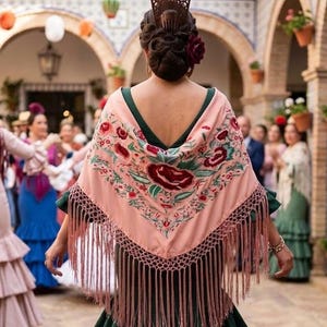 Può includere: Uno scialle triangolare color pesca tenue con intricati ricami floreali nei toni del rosso, verde e bianco. Lo scialle è rifinito con un bordo decorativo all'uncinetto e lunghe frange fluide lungo i bordi inferiori.