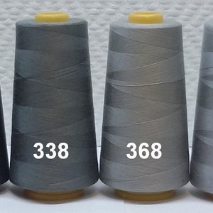 May include: Ten spools of thread in various shades of grey, from white to black. The spools are labelled with numbers: 001, 000, 374, 347, 338, 368, 366, 342, 310, and 334.