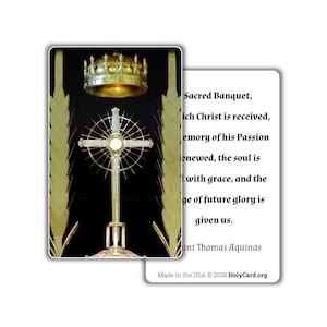 May include: A prayer card featuring a gold crown above a monstrance with a cross and sunburst design, flanked by wheat stalks on a black background. The reverse side displays black text of a prayer by Saint Thomas Aquinas on a white background.