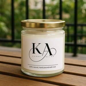 Peut inclure: Une bougie en pot de verre transparent avec un couvercle doré. L'étiquette blanche porte l'inscription "KA" et "KERRY ALLEN" en noir. Le bas de l'étiquette indique "100% naturel, fait à la main avec amour". La bougie est posée sur une surface en bois.