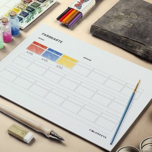 May include: A still-life composition featuring art supplies. A color chart labeled "FARBKARTE" is central, with paint tubes, watercolor paints, and small glass bottles with colored liquids. A paintbrush, eraser, and pen are also present.