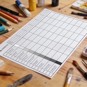 Könnte beinhalten: Ein Holztisch mit Kunstbedarf, darunter Bleistifte, Marker, Pinsel und eine Aquarellpalette. Ein weißes Papier mit Rastermuster und dem Text "COLOREETS" ist der Fokus, entworfen für Farbfelder und Tests.